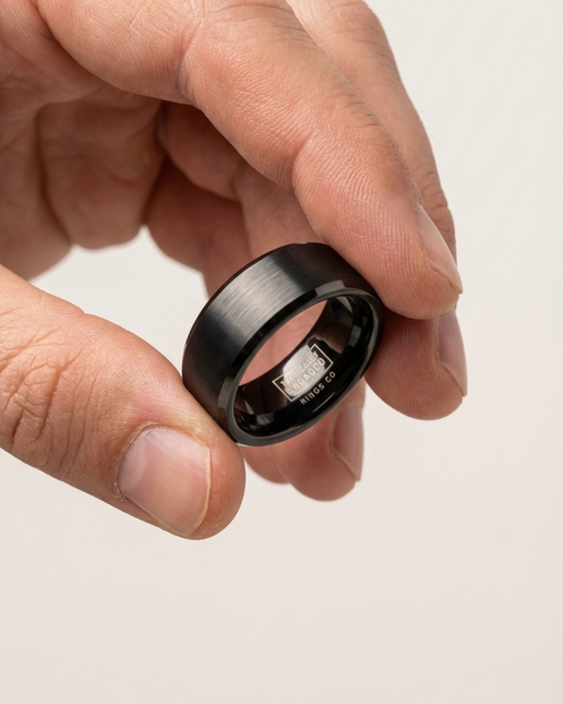 Smart ring being held between fingers on a light background