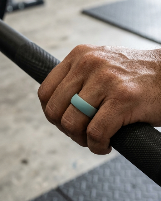 Hand holding a barbell with a greyring on a blurred gym background